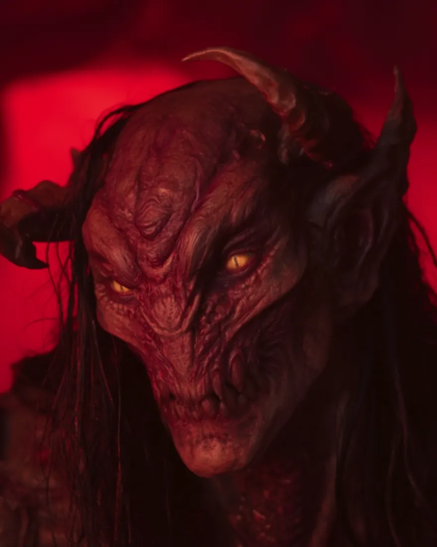 A Mekulak in the red of the pits, eyes burning yellow-orange over jagged curved teeth.